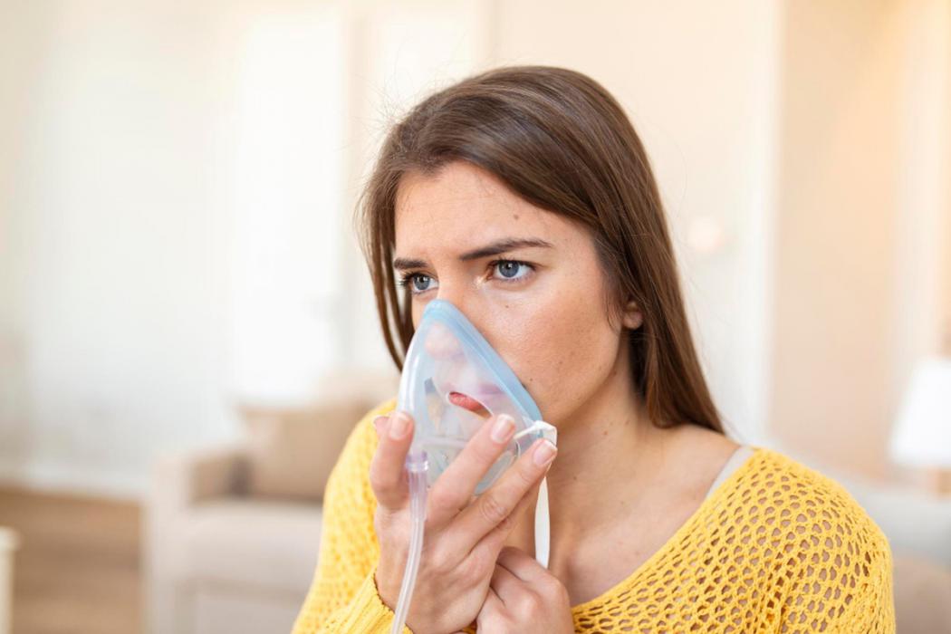chora kobieta robi inhalację nebulizatorem z maską
