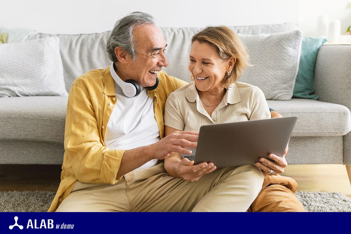 wesoła para seniorów z laptopem