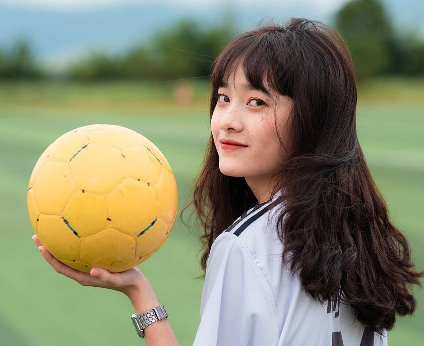 dziewczyna Azjatka z piłką nożną w ręku