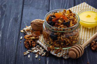 Granola in jar with nuts and dried fruit.