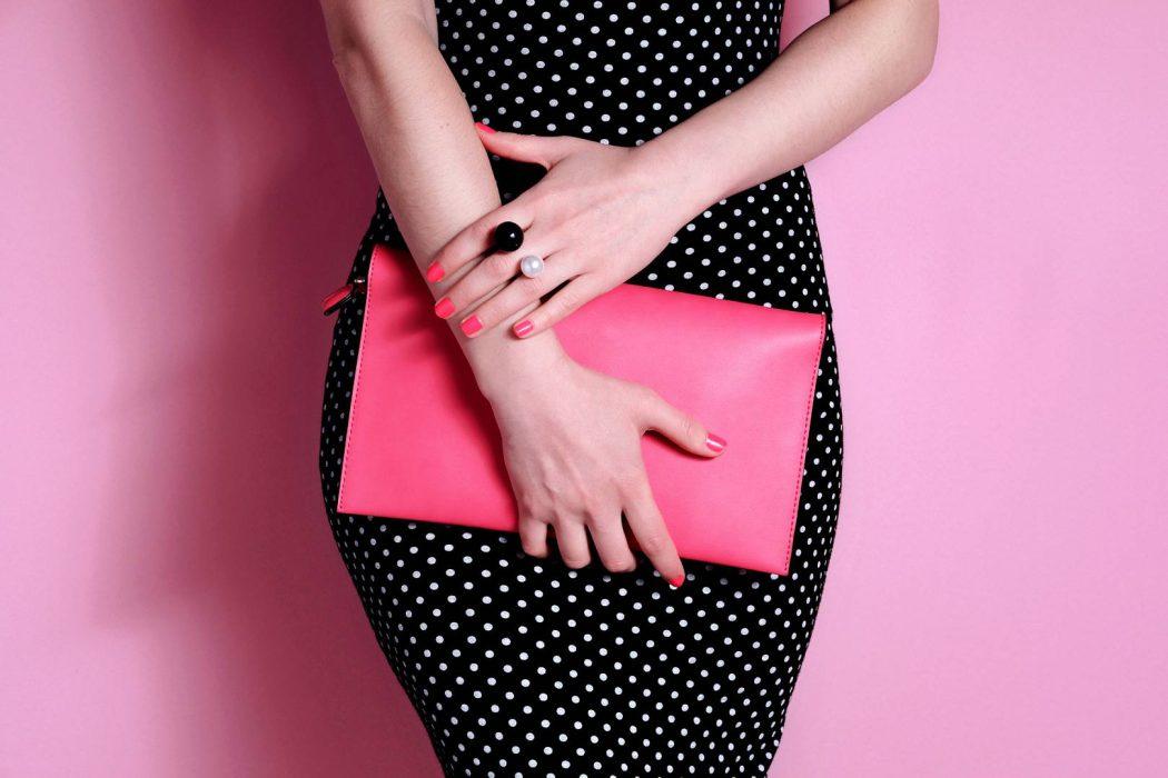 Close up shapely woman in evening black dress with pink bag