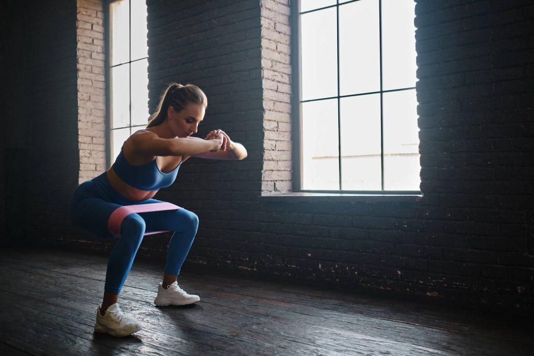 Crossfit healthy concept. Woman wearing sport clothing using resistance band