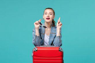 front view young female holding her sunglasses preparing vacation blue desk