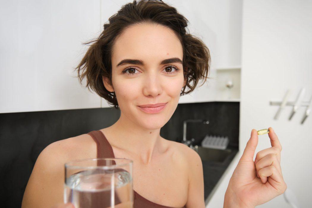 portrait sportswoman drinking water taking vitamins dietry supplements healthy skin having