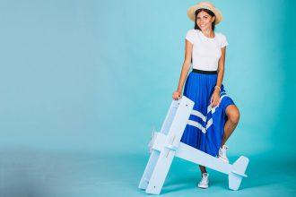 Woman with toy plane on blue background