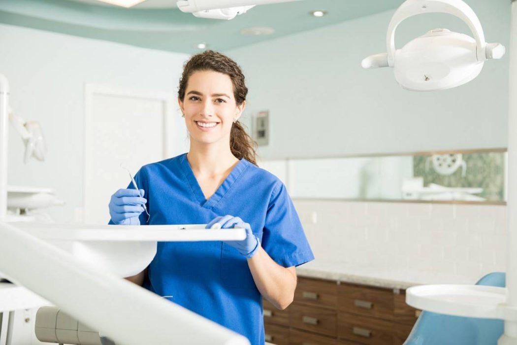Portrait Of Smiling Dentist Holding Dental Carver At Clinic